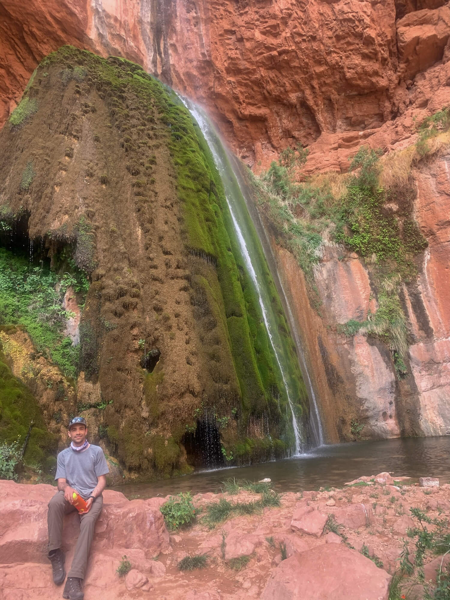 Hiker rests by Ribbon Falls an Oasis in the Grand Canyon